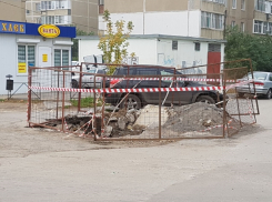 Первое обещание выполнено: наполненную водой и мусором огромную яму огородили забором и красной лентой 
