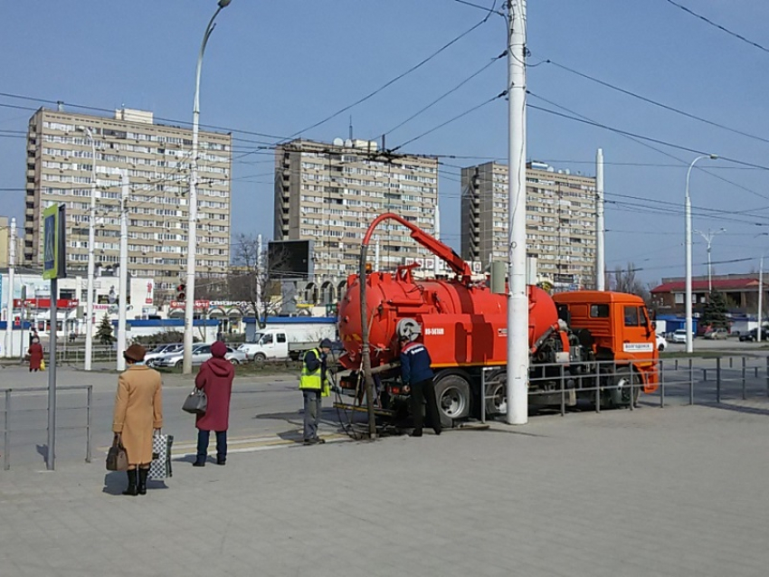 У Торгового центра оранжевый илосос чистит ливневку
