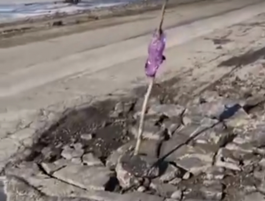 Вместо ремонта трассы Ростов-Волгодонск работники установили в яме предупреждающую палку с намотанным фиолетовым пакетом