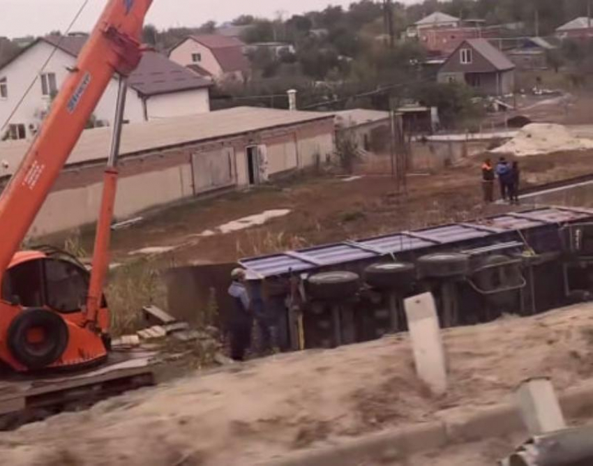 Сорвавшийся с трассы тонар поднимают двумя кранами в станице Красноярской 