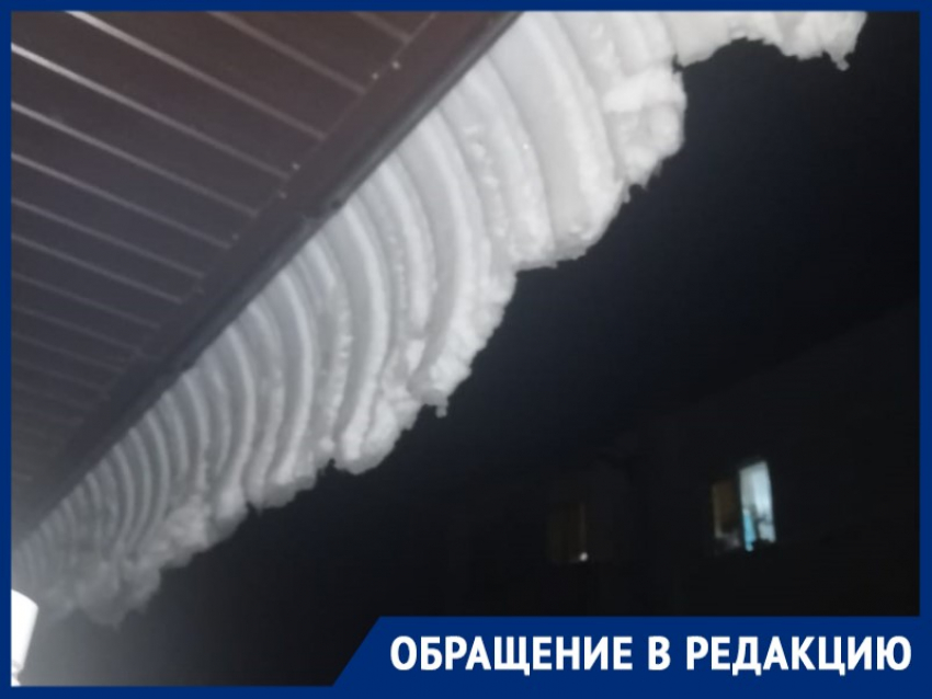 Глыбы мокрого снега свисают с крыш и козырьков подъездов МКД на Горького